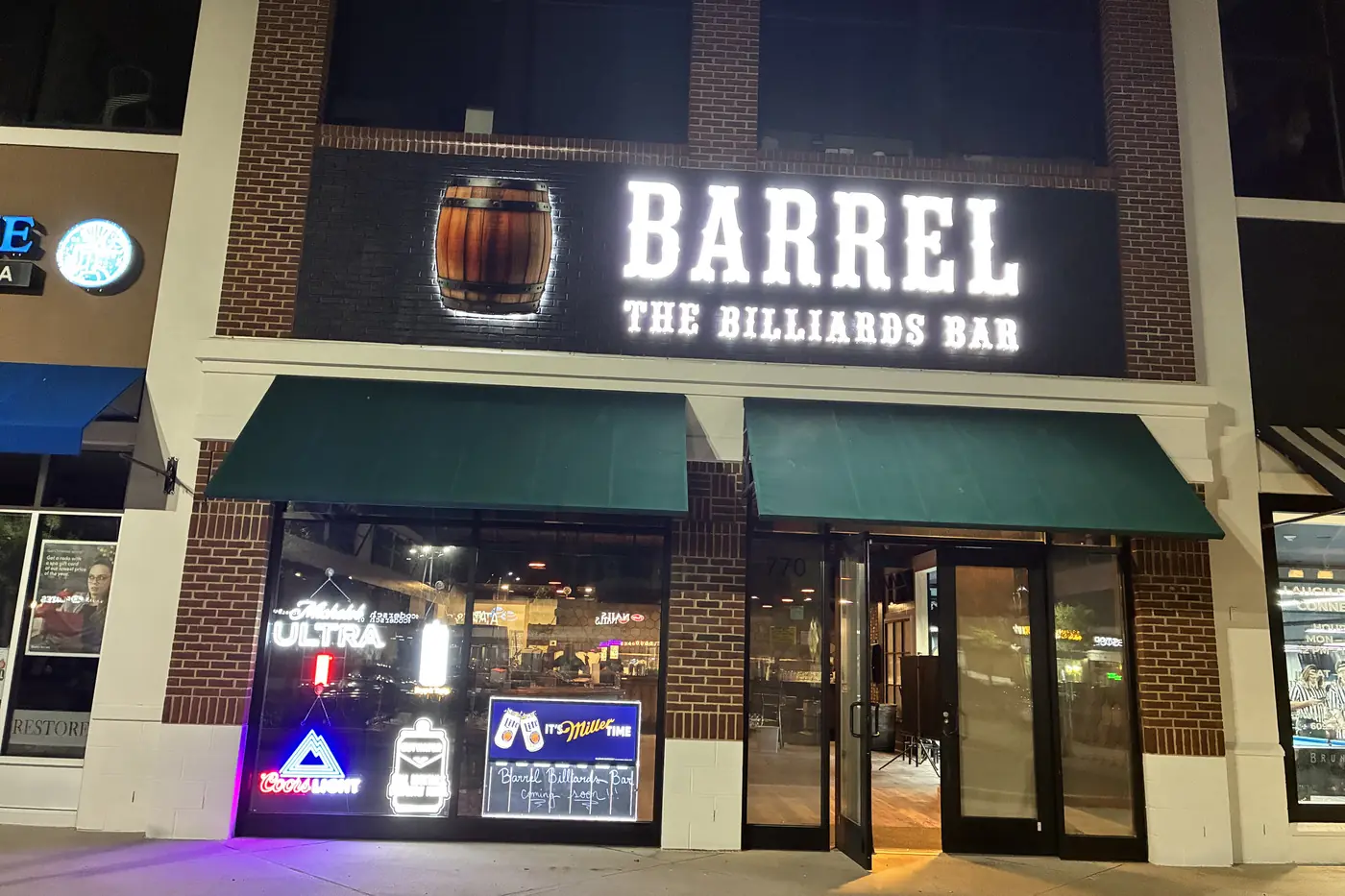 The illuminated Barrel — The Billiards Bar sign on the storefront next door