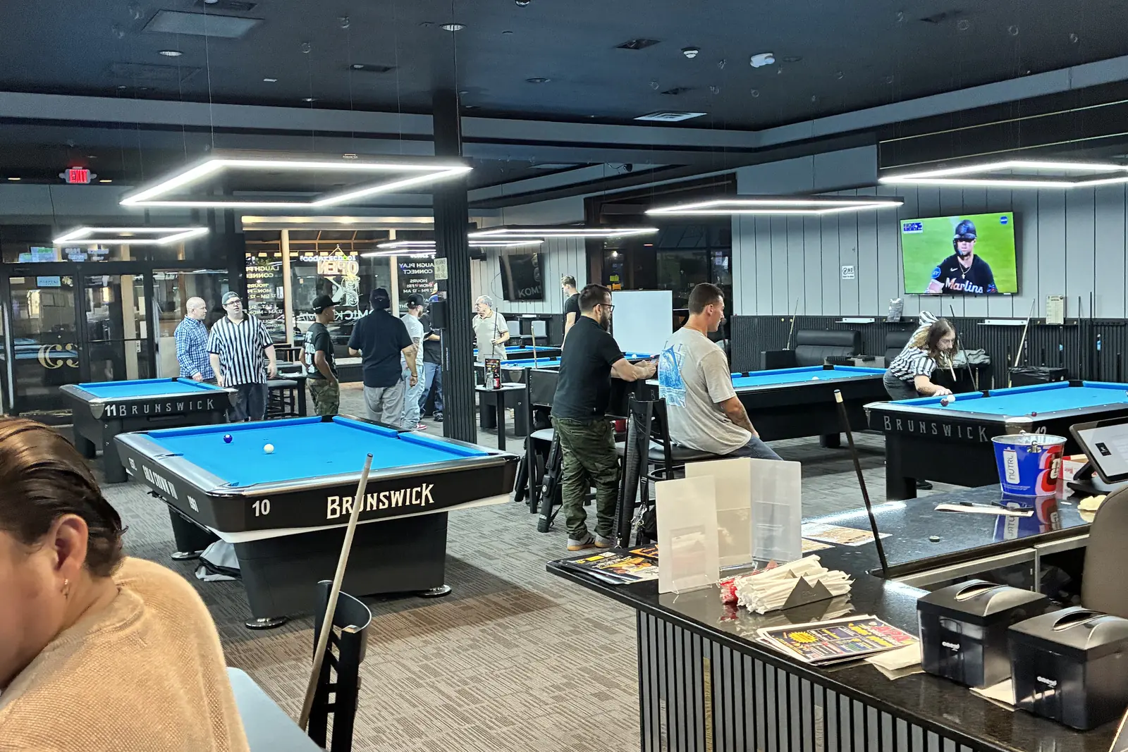The Komic Karma game hall, tables and LED light bars running the length of the room